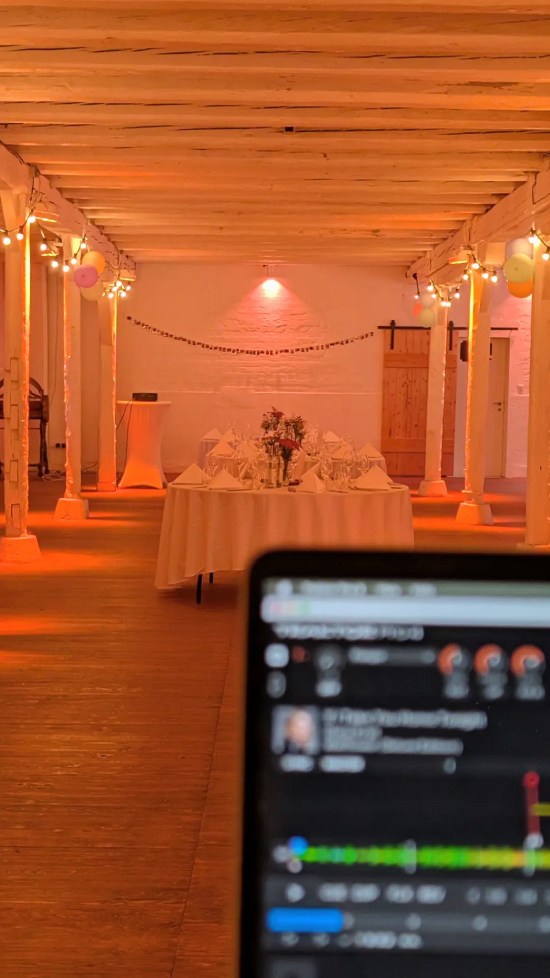 Warmes Ambiente-Licht in der Scheune mit gedeckter Hochzeitstafel – Feier in Schleswig-Holstein